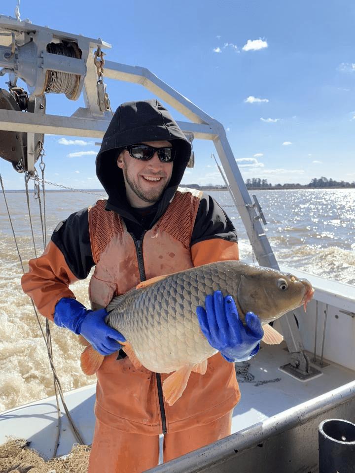 Brian holds a fish onboard a boat