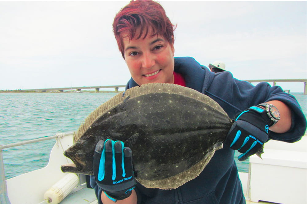 Sara Cernadas-Martín holds a fluke in Shinnecock Bay