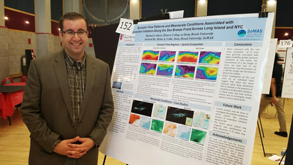 Michael Colbert stands next to his poster at URECA