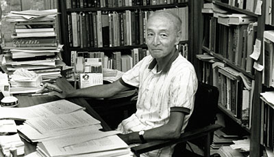 Akira Okubo sits in his office surrounded by his library of books