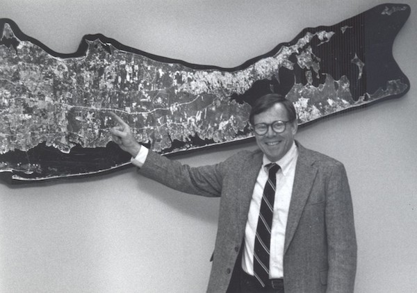 Jerry Schubel stands in front of a map of Long Island