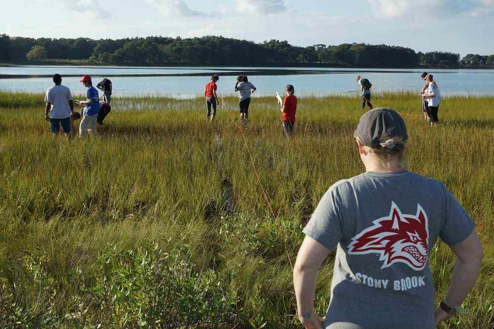 A student watches her classmates explore a marsh