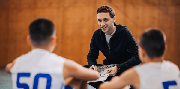 A basketball coach mapping out a play on a whiteboard