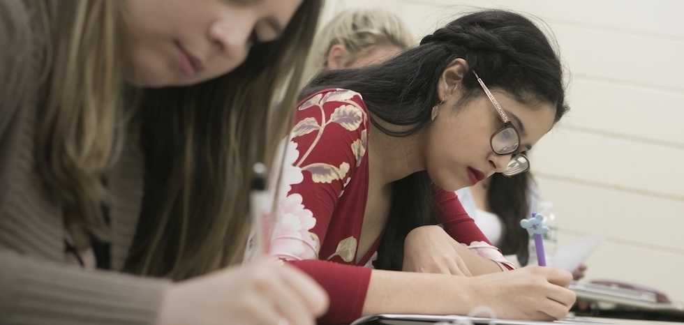 Two MAT math students writing out lesson plans on paper