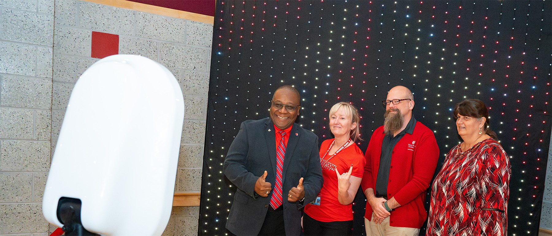 University staff members standing together and smiling at an event.