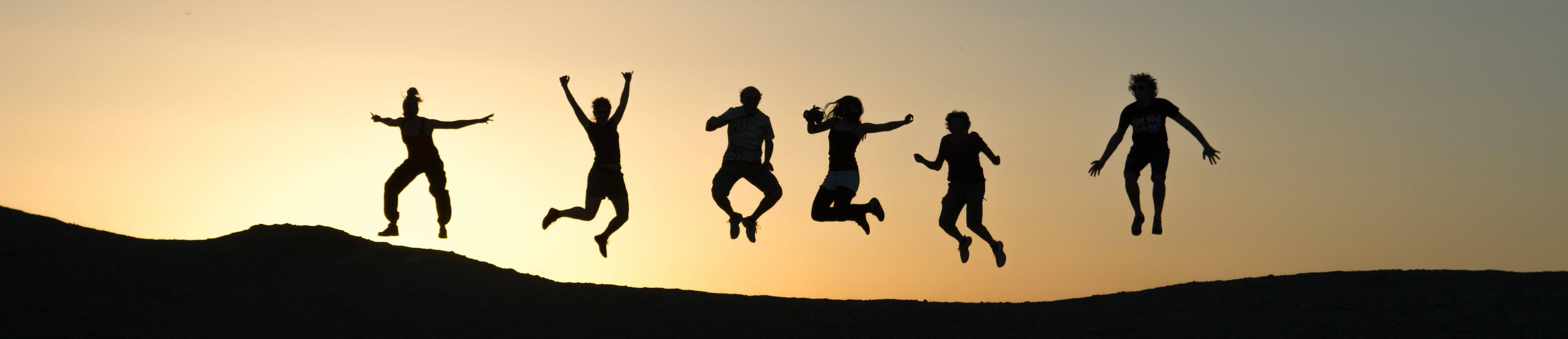 Students jumping outside in the sunset