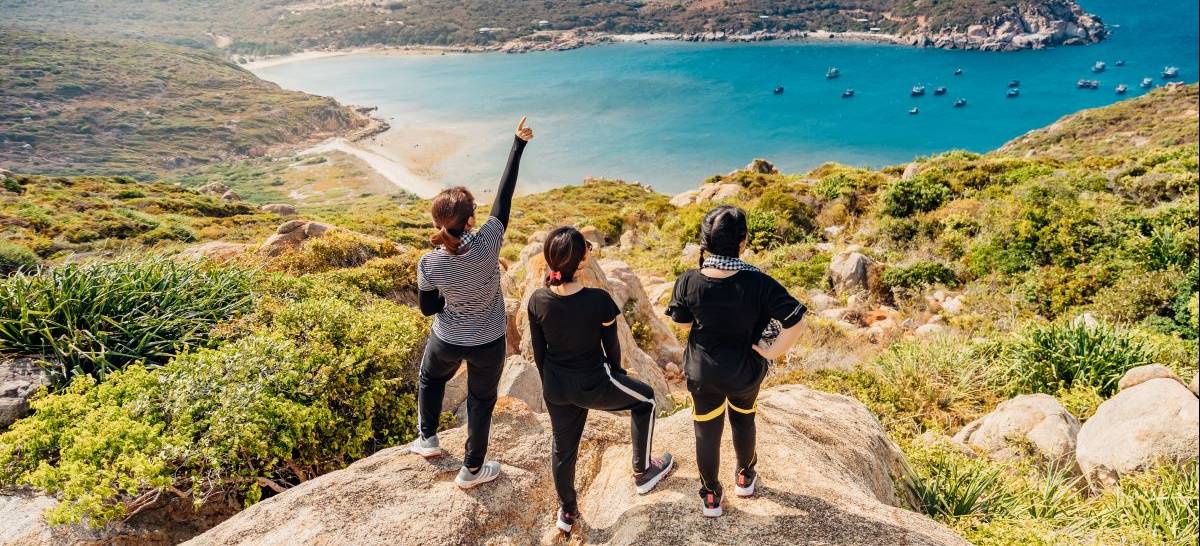 Hikers on a mountain top overlooking the water