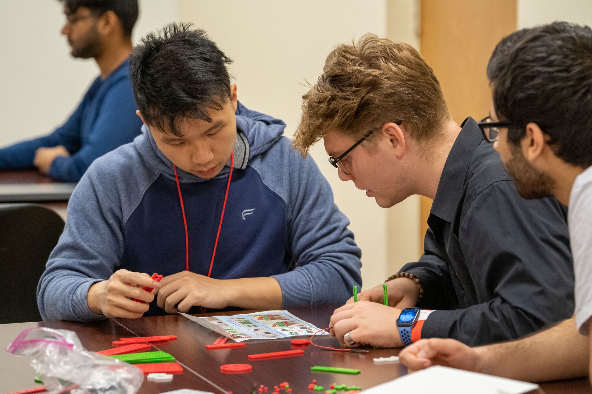 Two students working at a table with 3D printed materials.